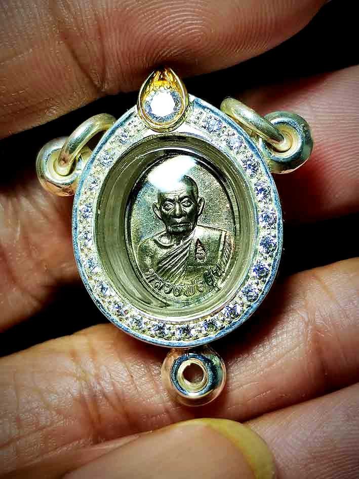 2800.- เหรียญเม็ดแตง รุ่นแรก หลวงพ่ออุ้น วัดตาลกง จ.เพชรบุรี ปี48 เนื้อนวะ เลี่ยมเงิน3ห่วง ฝังเพชร CZ งานสั่งทำ