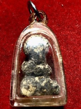 พระปิดตาเนื้อผงคลุกรักพิมพ์เล็ก เลี่ยมพลาสติก  ไม่ทราบที่