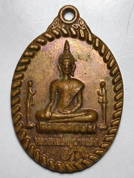 เหรียญพระพุทธรูปปางมารวิชัย (หลวงพ่อปากแดง) วัดไพศาลสถิตย์ (วัดปากพยิง) ตำบลปากพูน อำเภอเมือง จังหวัดนครศรีธรรมราช มีความศักดิ์สิทธิ์เรื่องความรัก โชคลาภ และความสงบร่มเย็น