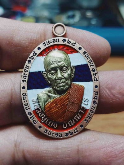 2-1156 วัดใจ 150 เหรียญชนะจน 168 หลวงปู่เถิง วัดบ้านอาลัย จ.ศรีสะเกษ 2568 ทองแดงซาติน ลงยาลายธงชาติ หน้ากากทองทิพย์ซาติน ลงยาขอบ จีวร หลัง หมายเลข 46 สร้าง 60 เหรียญ กล่องเดิม