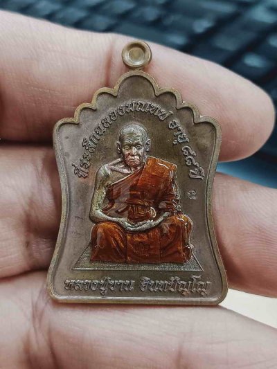 2-1362 วัดใจ 100 เหรียญฉลองมณฑป หลวงปู่ขาน สำนักปฏิบัติธรรม ปล.หนองอ้อ จ.มุกดาหาร 2568 ทองแดงรมมันปู ลงยาจีวร หมายเลข 52 กล่องเดิม