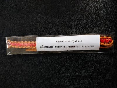 120.-ตะกรุดกันภัย สายรัดข้อมือ หลวงปู่หงษ์ วัดเพชรบุรี จ.สุรินทร์ ปี2547 สีเหลืองแดง ดอกที่ 1